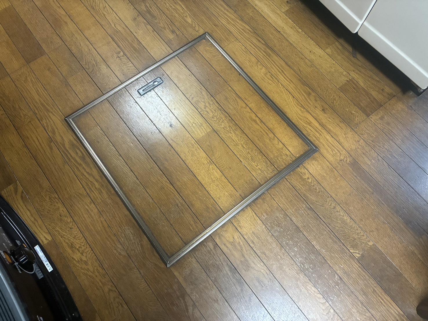 床 ビフォー（既存のフローリングと床下収納の点検口）
