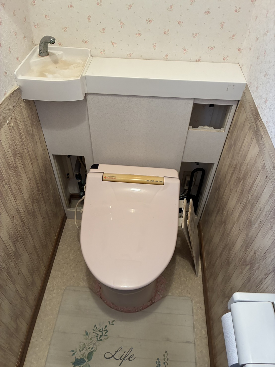 改装前のトイレ。背面に手洗い器つきのタンク棚がある